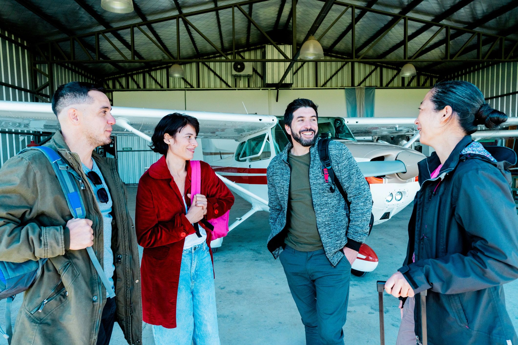 Friends talking beside an airplane hangar
