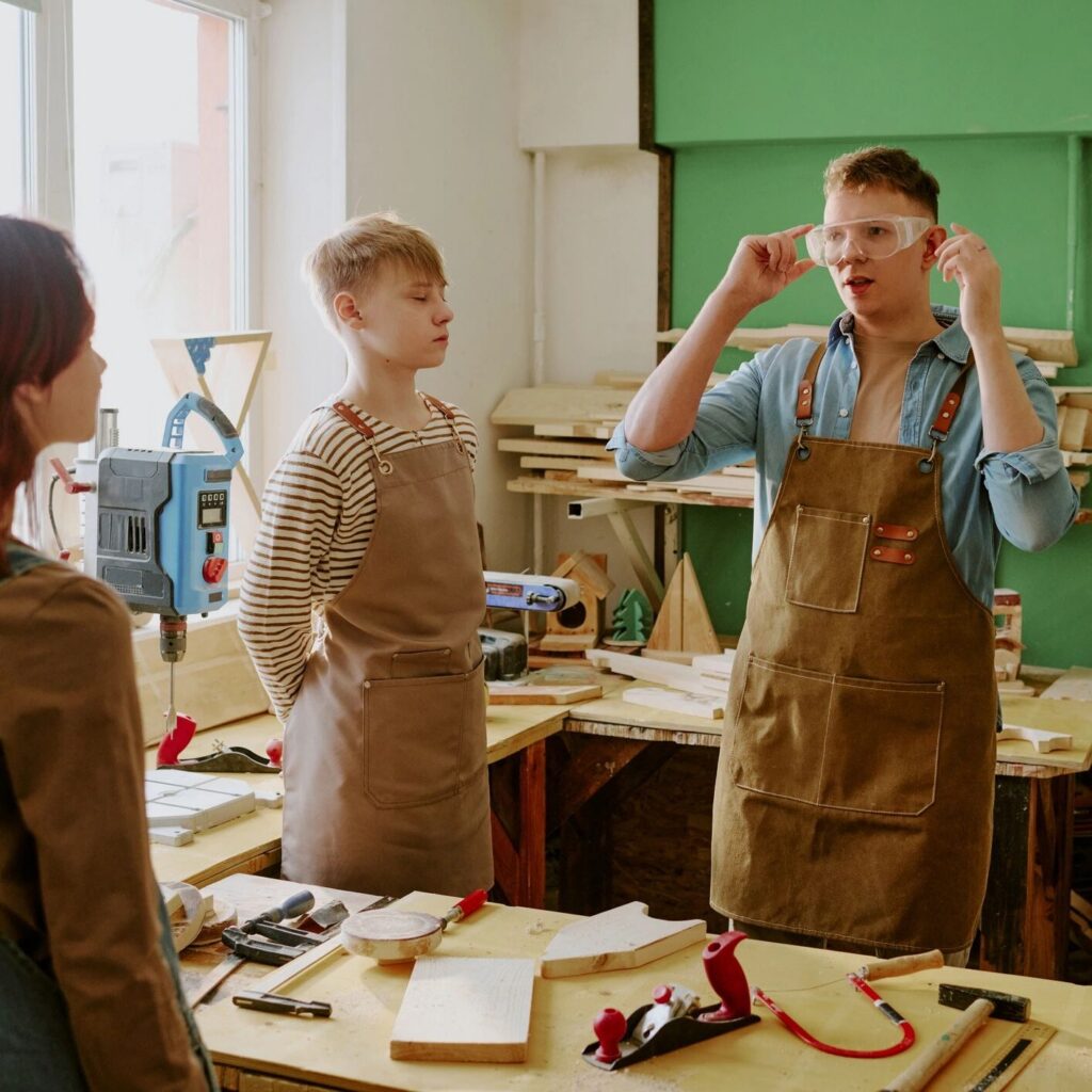 Teenager Boy Teaching Woodworking Safety during Classroom Workshop